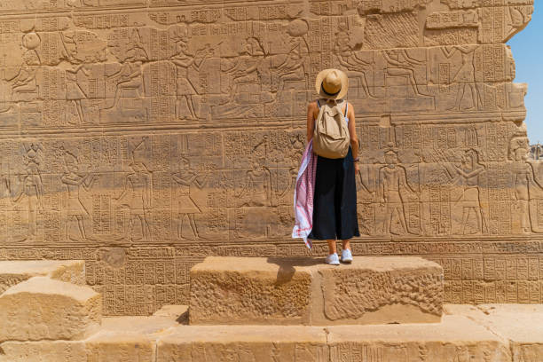 Woman standing in front of Temple of Philae aka Temple of Isis in Aswan Egypt